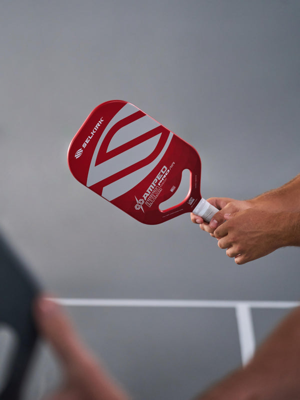 Selkirk AMPED Pro Air Epic pickleball paddle held in hand, featuring red and white design.