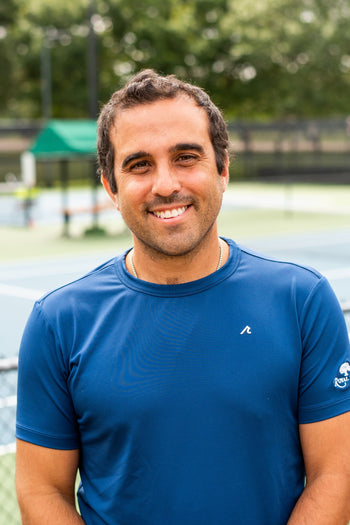 Jarrett Chirico, the Director of Racquets at Royal Oaks Country Club in Dallas, stands on a pickleball court.