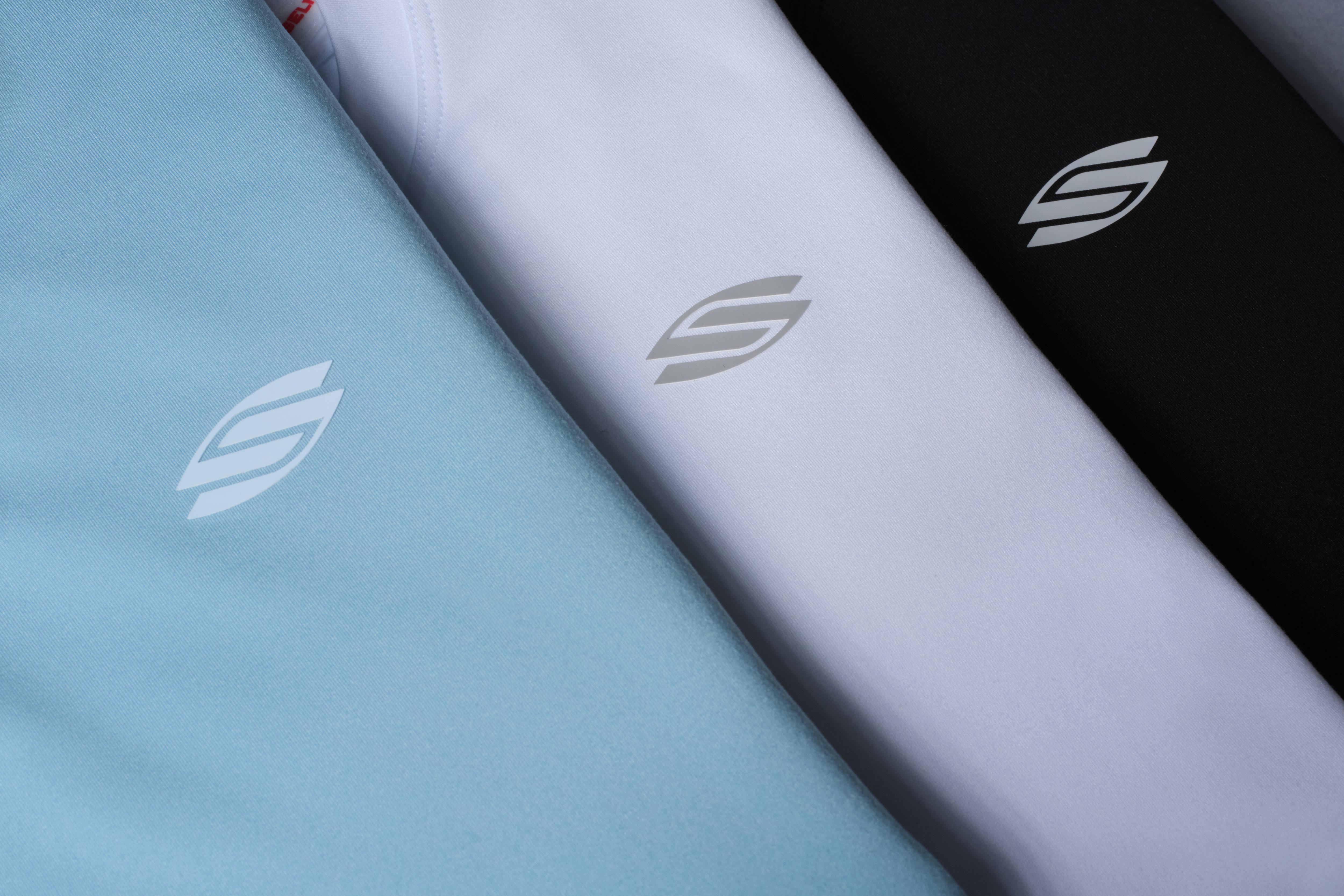 Three women's training tees in blue, white, and black with logos