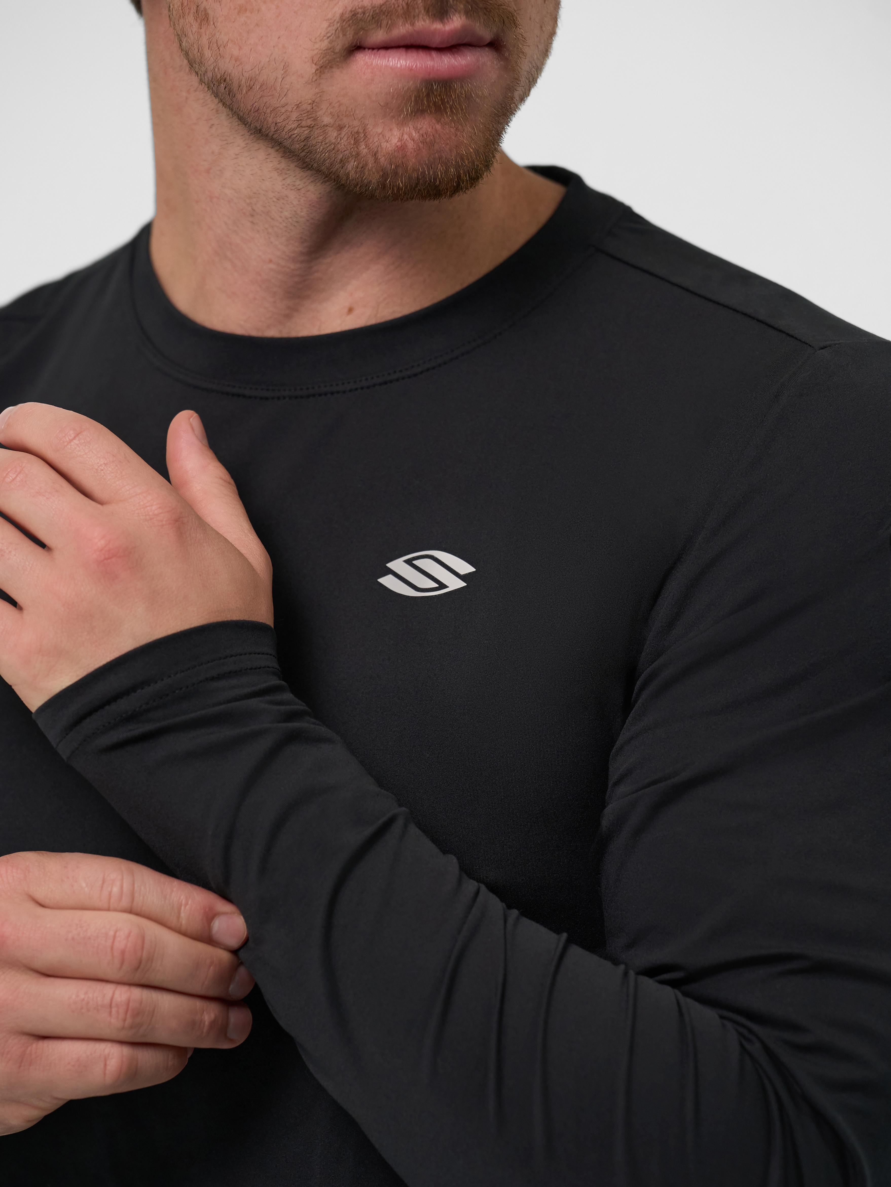 Model wearing a black long sleeve athletic shirt with logo on chest