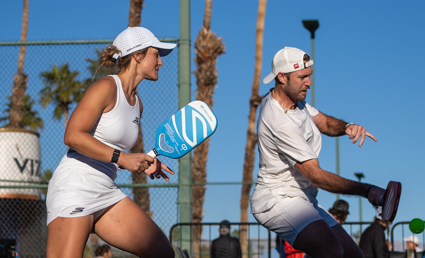 Two pickleball players using Selkirk paddles on the court, showcasing the sport.