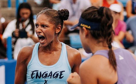 A female athlete celebrating passionately during a match, with another player beside her.