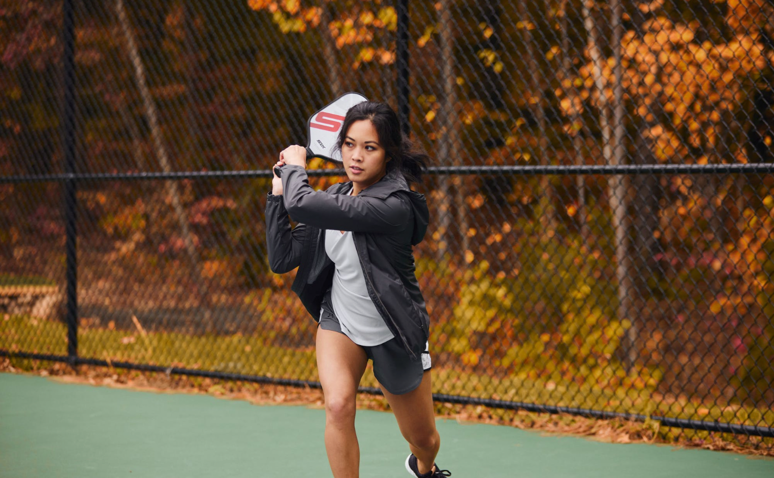 A female pickleball player preparing to hit a shot on the court.