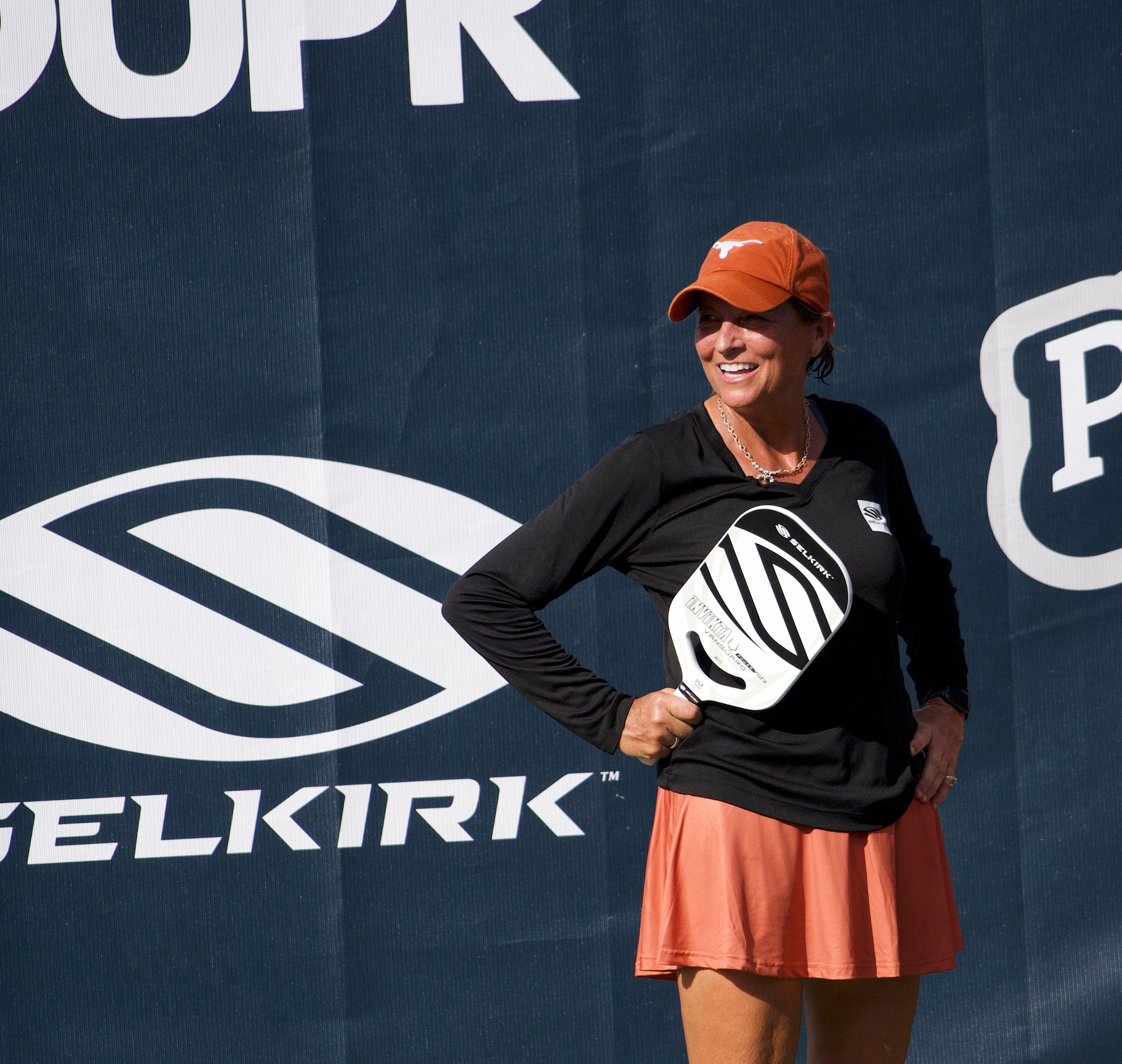 Sherri Steinhauer smiling while holding a Selkirk pickleball paddle on the court
