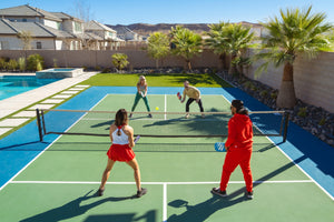 Four players play Pickleball on an outdoor court beside a pool