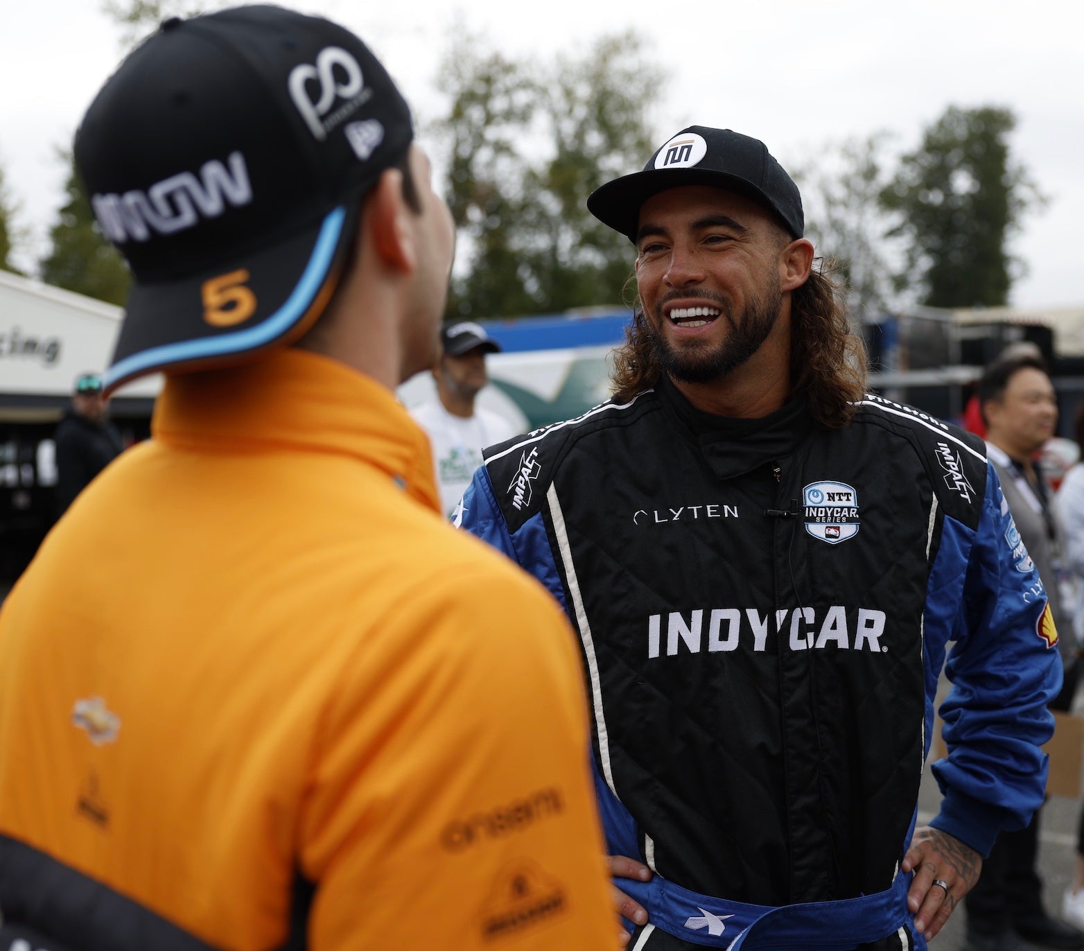 Tyson McGuffin smiling while talking to an INDYCAR driver at the Grand Prix of Portland