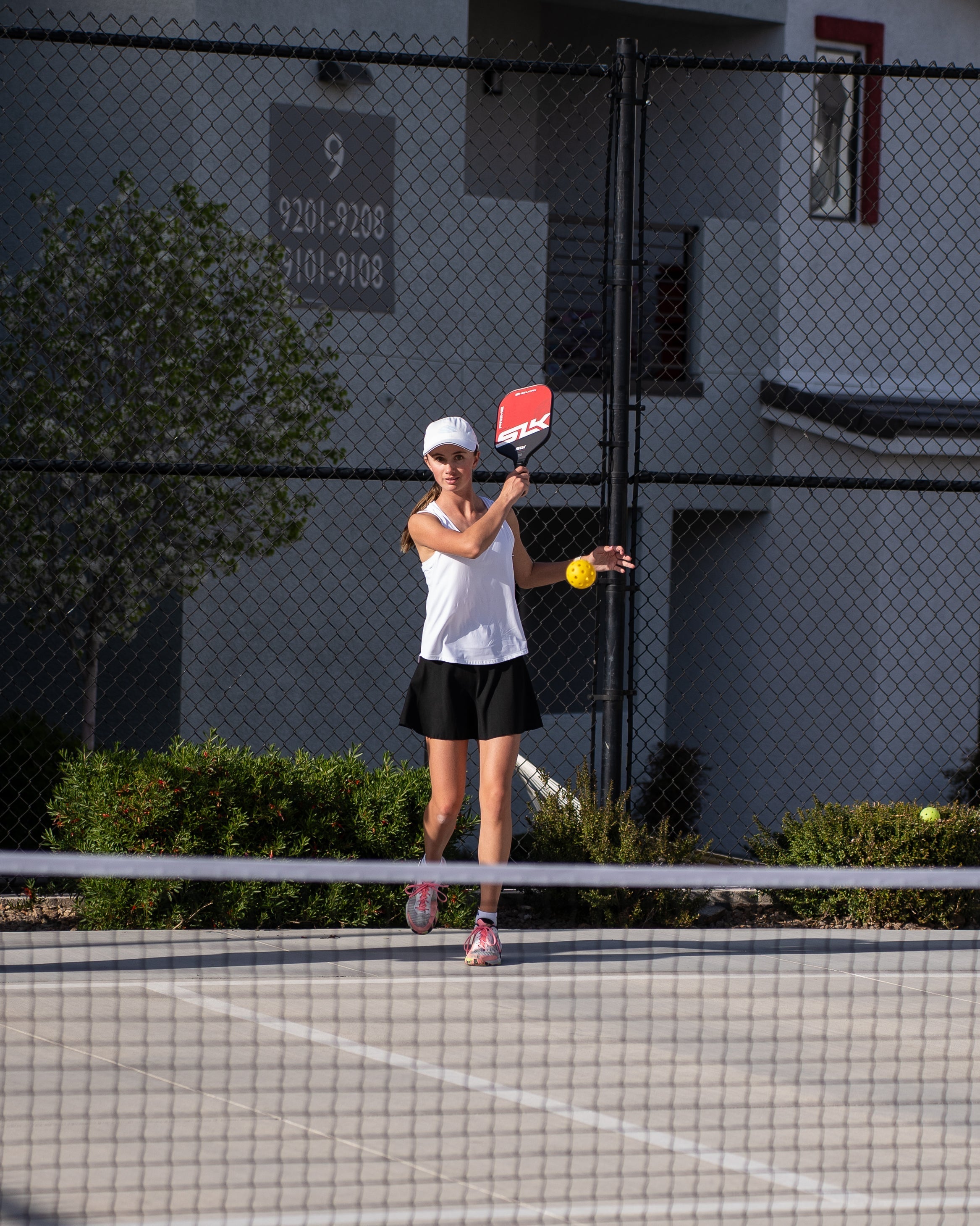 A player preparing to serve in pickleball, demonstrating a let serve scenario.