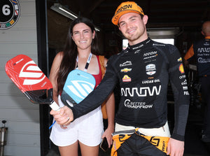 Rachel Rohrabacher and INDYCAR driver holding Selkirk Luxx Control Air paddles at the Indy 200 event.