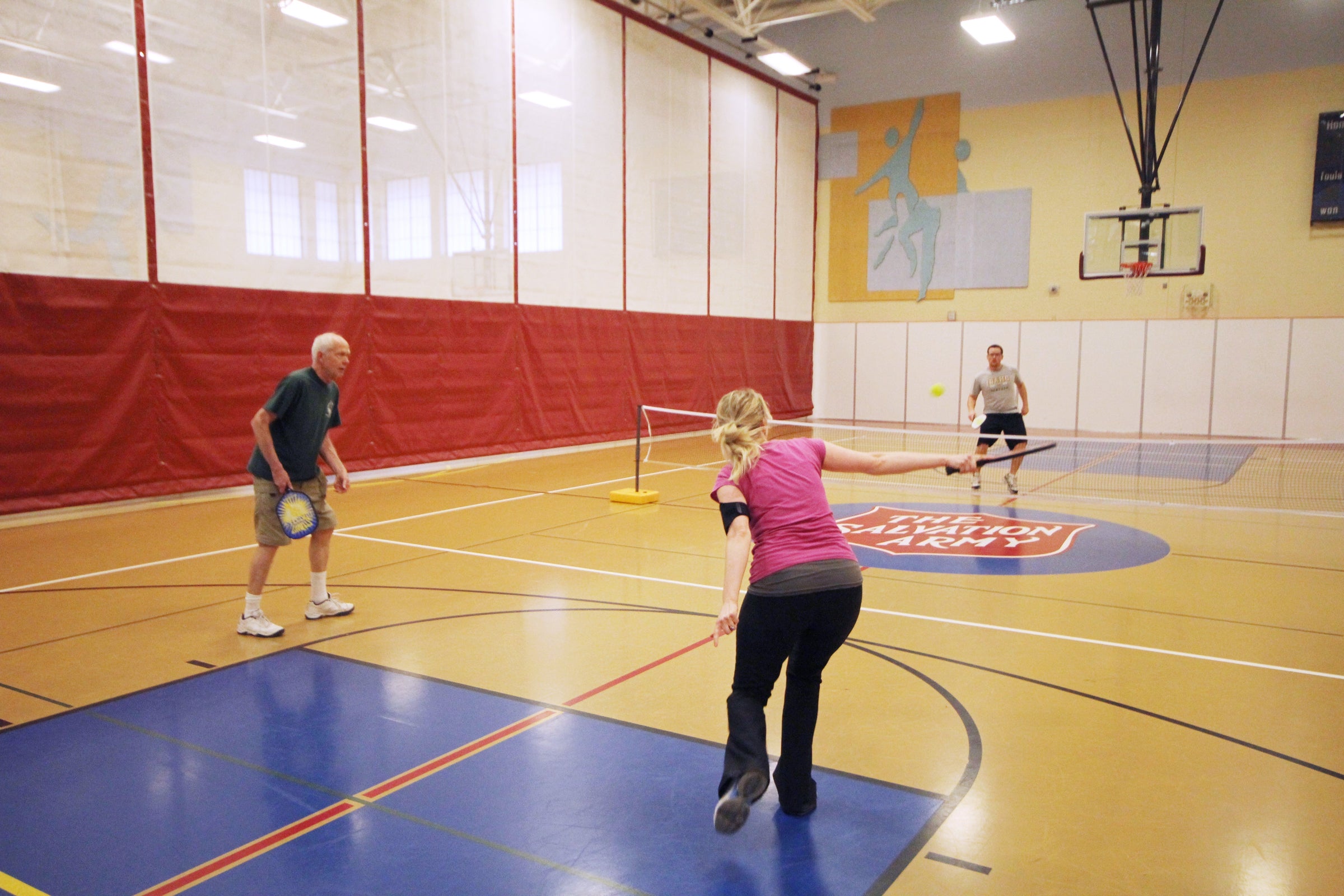 Three people play pickleball on indoor courts at the Kroc Center in Coeur d’Alene, Idaho