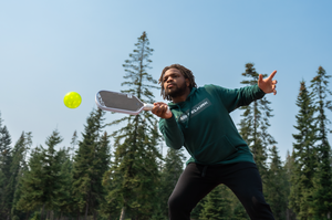 A man hits a volley with his Selkirk ERA paddle on an outdoor court. 