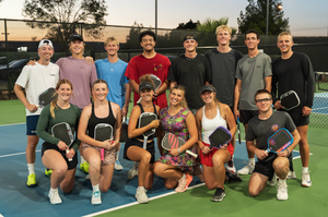 The Utah Tech pickleball team smiles at the camera as they hold up their Selkirk pickleball paddles. 