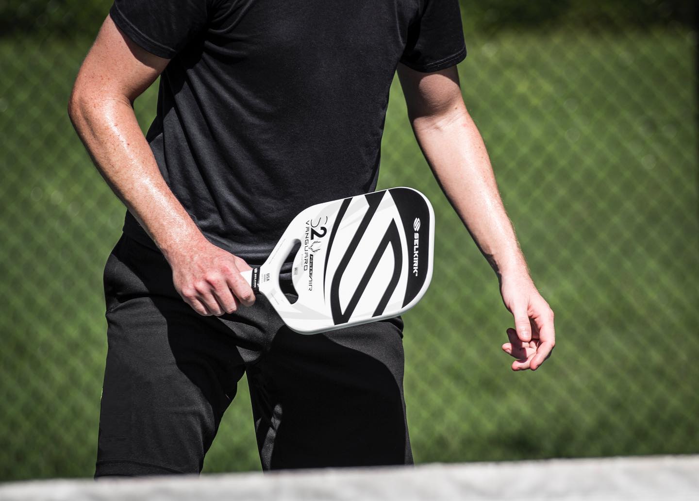A player holding a Selkirk VANGUARD S2 pickleball paddle on the court.