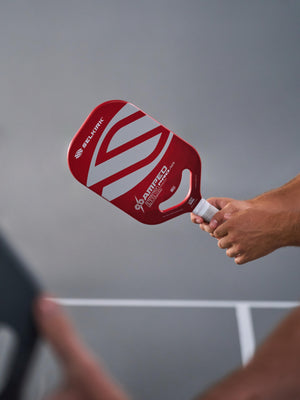 Selkirk AMPED Pro Air Epic pickleball paddle held in hand, featuring red and white design.