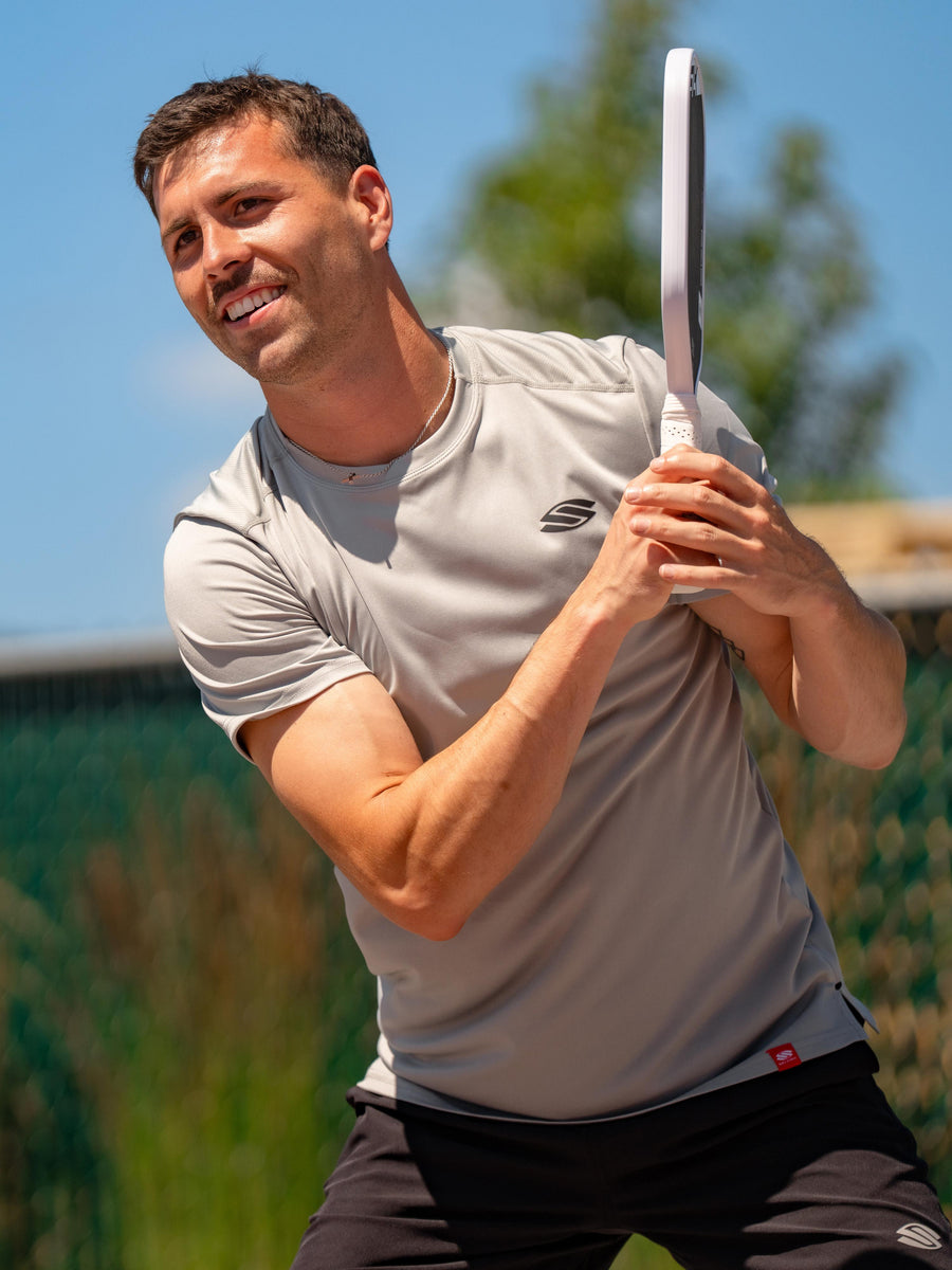 A man plays pickleball wearing shorts and a shirt by Selkirk Sport