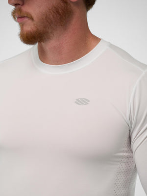 Male model wearing white fitted long-sleeve performance shirt with small gray logo on left chest and side ventilation holes.