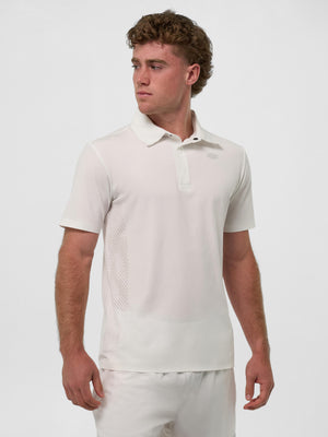 Male model in white short‑sleeve polo and matching pants, standing with hands at his sides, looking left.