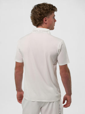 Man seen from back wearing white polo and matching shorts with visible SELKIRK branding on collar and shorts