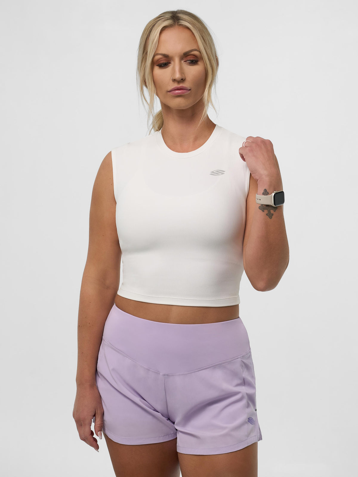 Model wearing Women's Pro Line Cap Sleeve Fitted Tee in Chalk, paired with purple shorts.