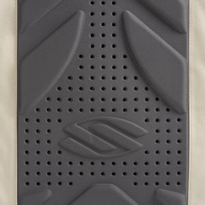 Perforated charcoal foam lumbar pad with embossed double-chevron logo and beige fabric border.
