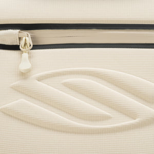 Close-up of Pro Line Tour Bag pickleball backpack exterior showing beige fabric texture, zipper pull, and embossed Selkirk chevron logo