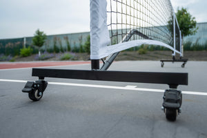 SLK Prime Portable Pickleball Net with wheels on a court