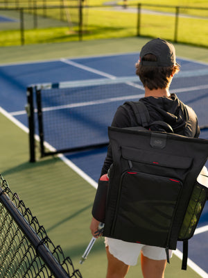 Player carrying the Selkirk Pro Line 2.0 Tour 35L backpack onto the court