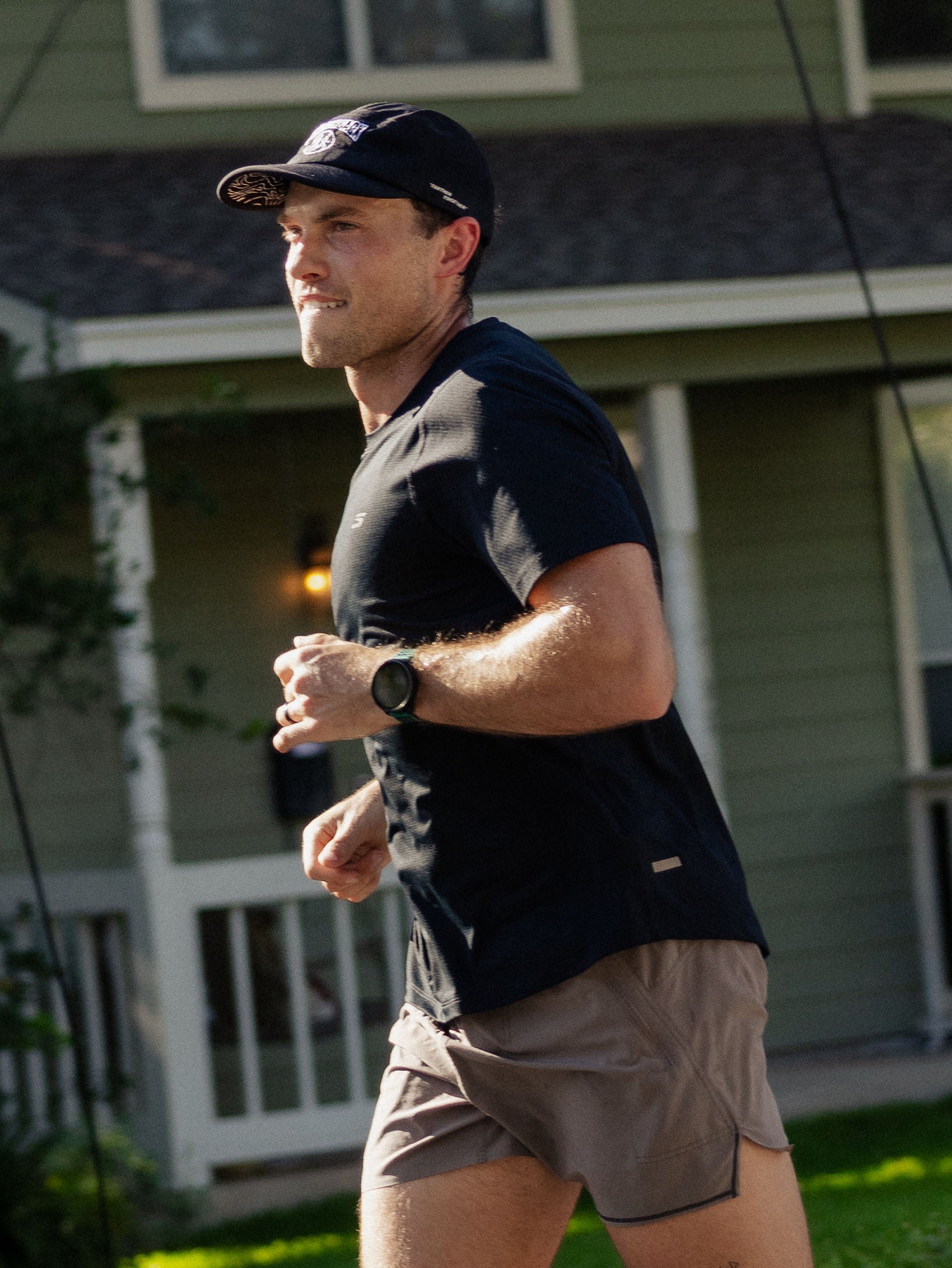 A close-up image shows a man jogging in front of a green house in Austin, Texas. 