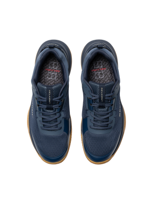 Top-down view of navy athletic sneakers with gum soles and patterned insoles.