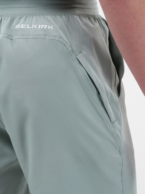 SELIKIRK logo at rear waist on light sage-green athletic shorts showing zippered side pocket and waistband