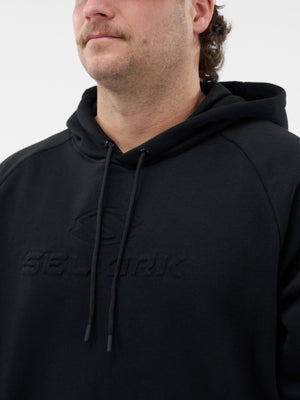 Man wearing black hoodie with embossed 'SELURIK' logo across chest