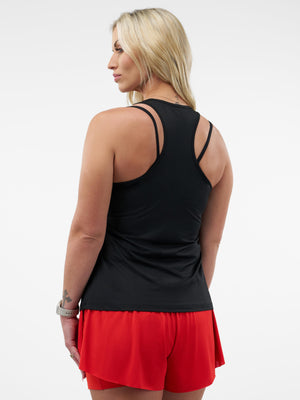 Rear view of woman wearing black racerback tank top with double shoulder straps and red athletic shorts.