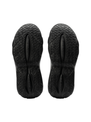 Bottom view of Selkirk Renew Pickleball Recovery Shoe showing black molded EVA outsoles with textured tread and ‘WE ARE HUMAN’ imprint
