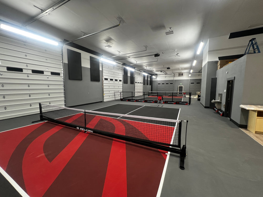 Selkirk Pickleball courts inside Coeur d'Alene pro shop with red and black court surfaces and portable Selkirk nets